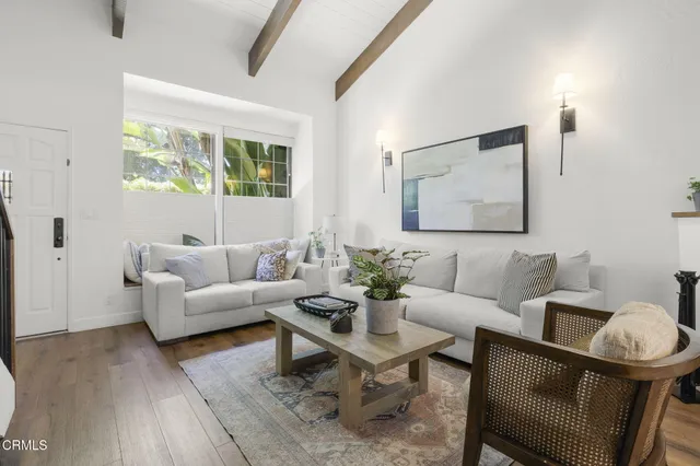 a living room with furniture a rug and a window