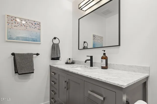 a bathroom with a sink vanity and a mirror