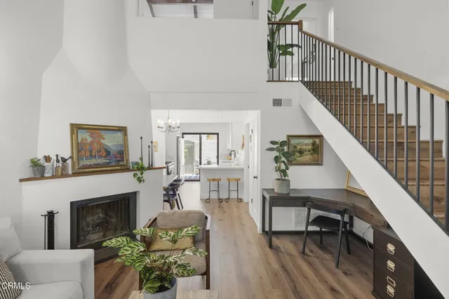 a living room with furniture a fireplace and a potted plant