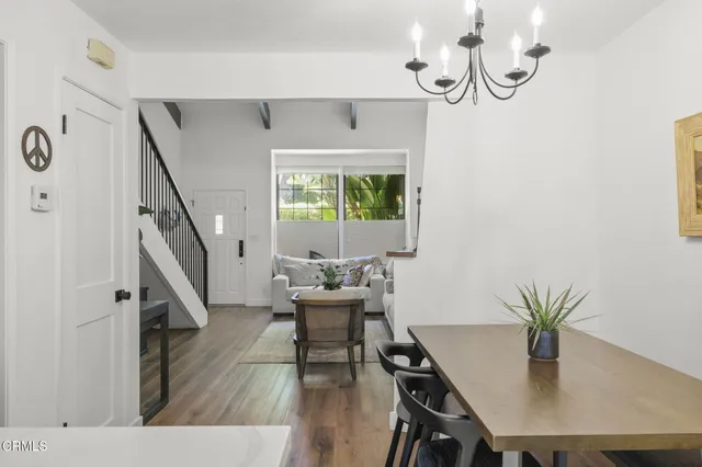 a dining room with furniture potted plants and wooden floor