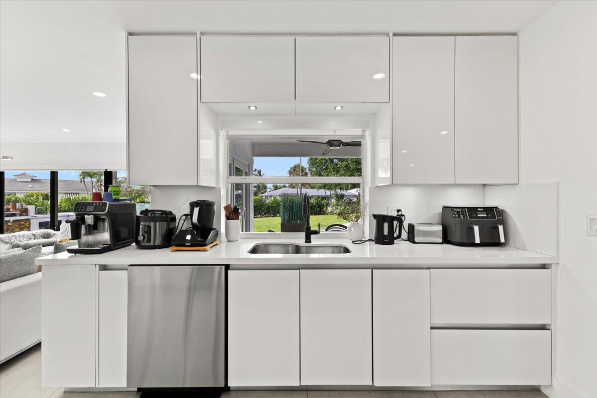 1049 West Palmetto Park Road Boca Raton, FL 33486 - Photo 11 of 40 a kitchen with a sink dishwasher and white cabinets
