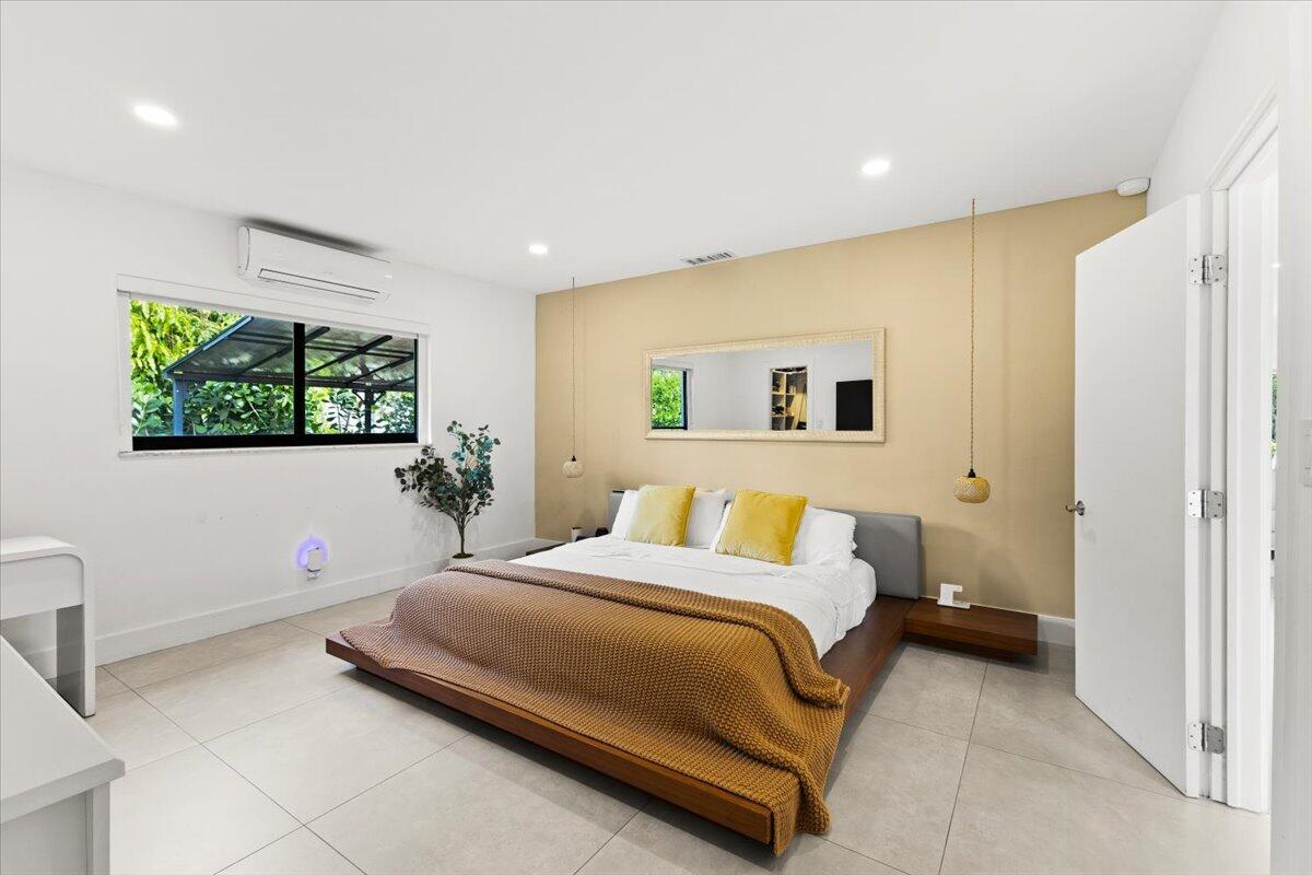 1049 West Palmetto Park Road Boca Raton, FL 33486 - Photo 17 of 40 a bedroom with a bed and a flat screen tv