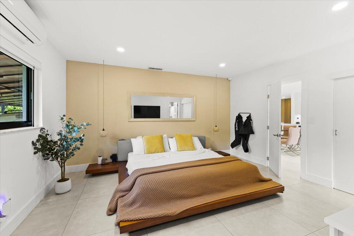 1049 West Palmetto Park Road Boca Raton, FL 33486 - Photo 18 of 40 a bed room with a bed and a potted plant