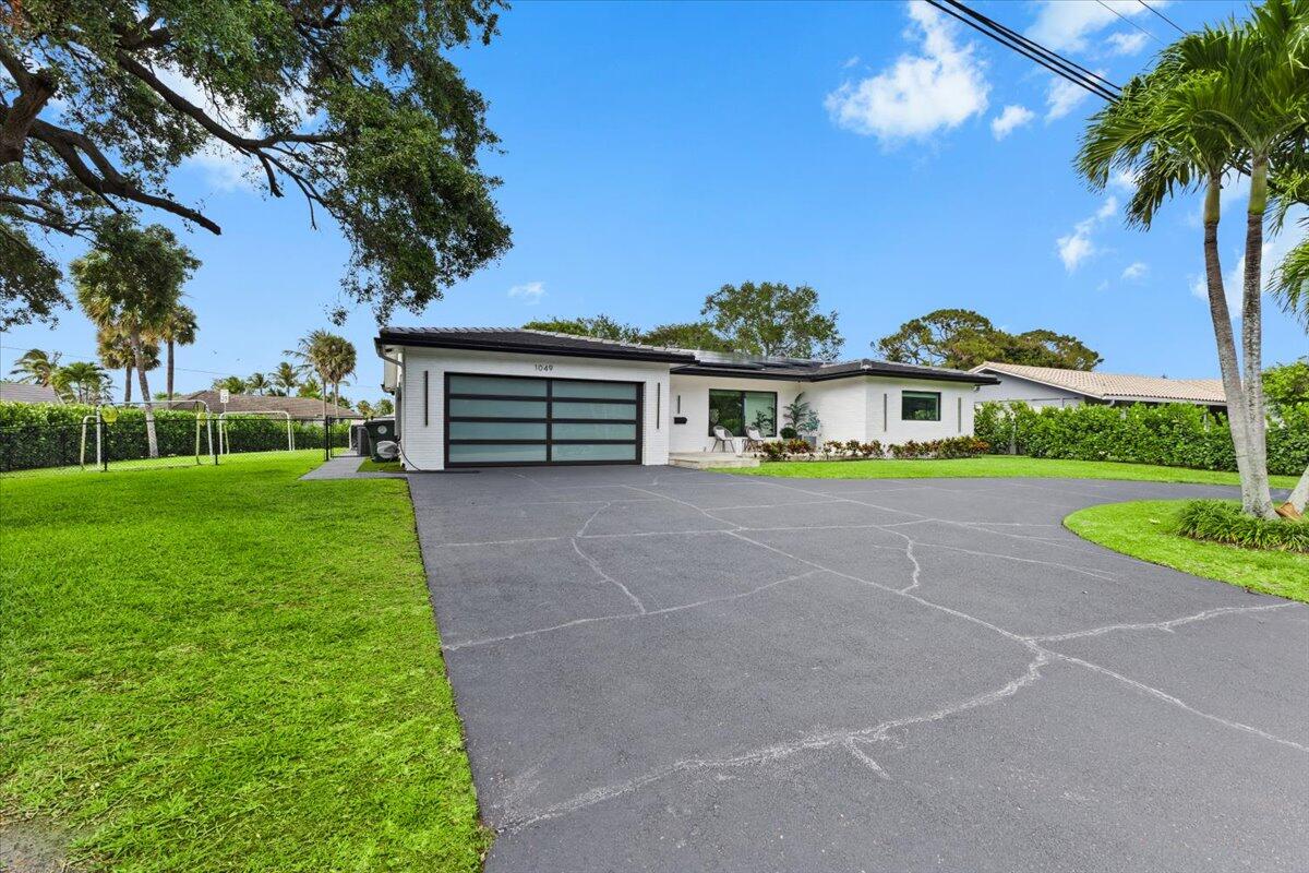 1049 West Palmetto Park Road Boca Raton, FL 33486 - Photo 2 of 40 a view of a house with a yard and potted plants