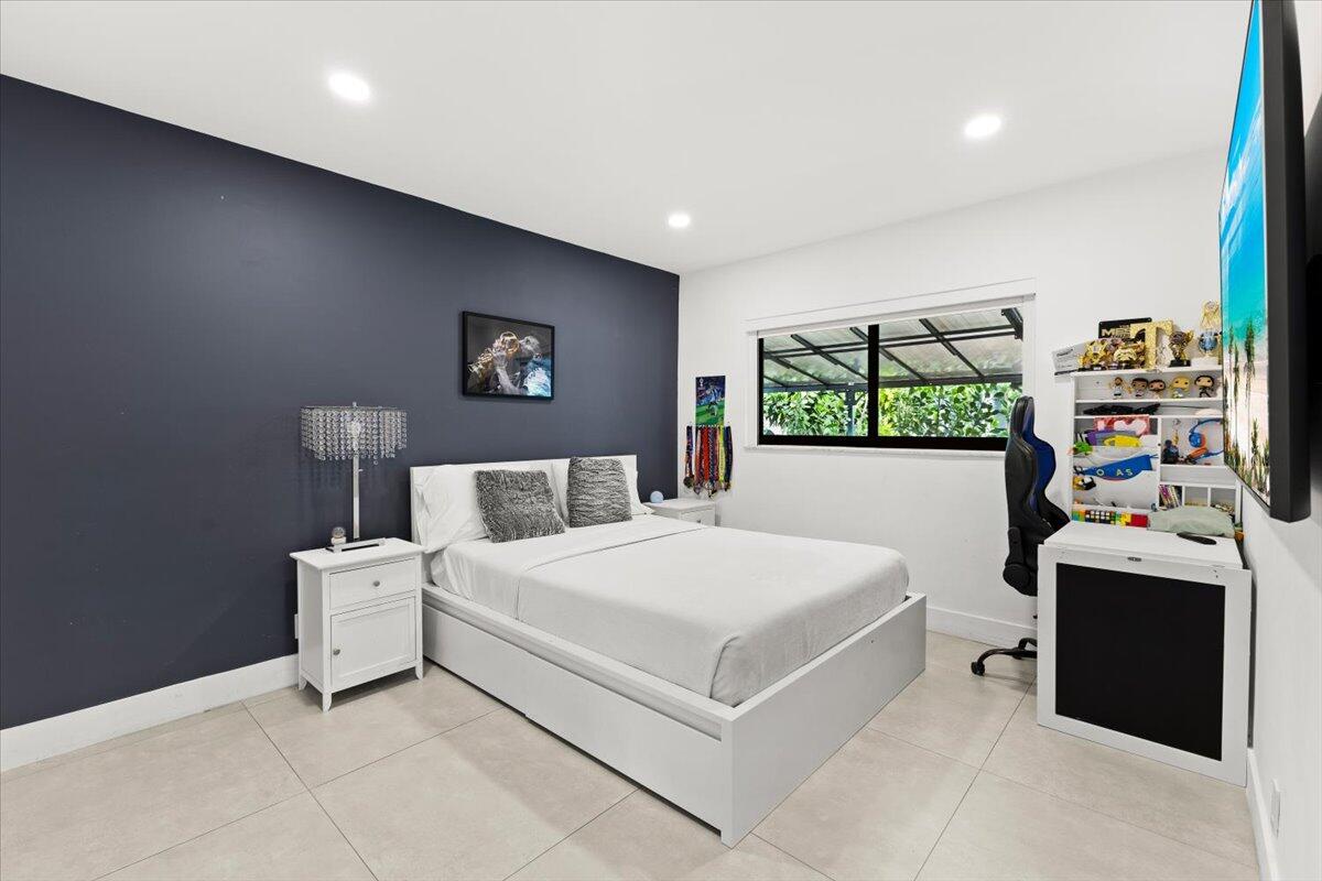 1049 West Palmetto Park Road Boca Raton, FL 33486 - Photo 21 of 40 a bedroom with a bed and a flat tv screen on the dresser