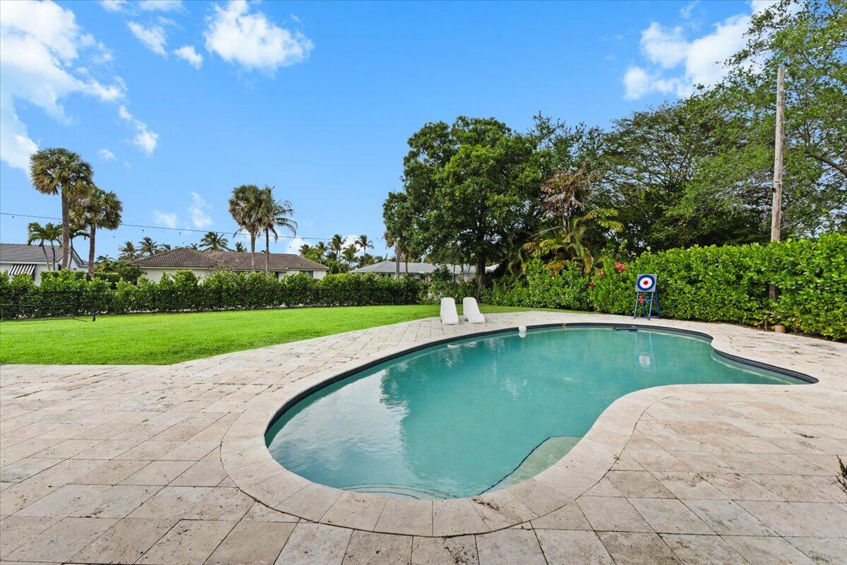 1049 West Palmetto Park Road Boca Raton, FL 33486 - Photo 30 of 40 a view of a swimming pool and trees in the background