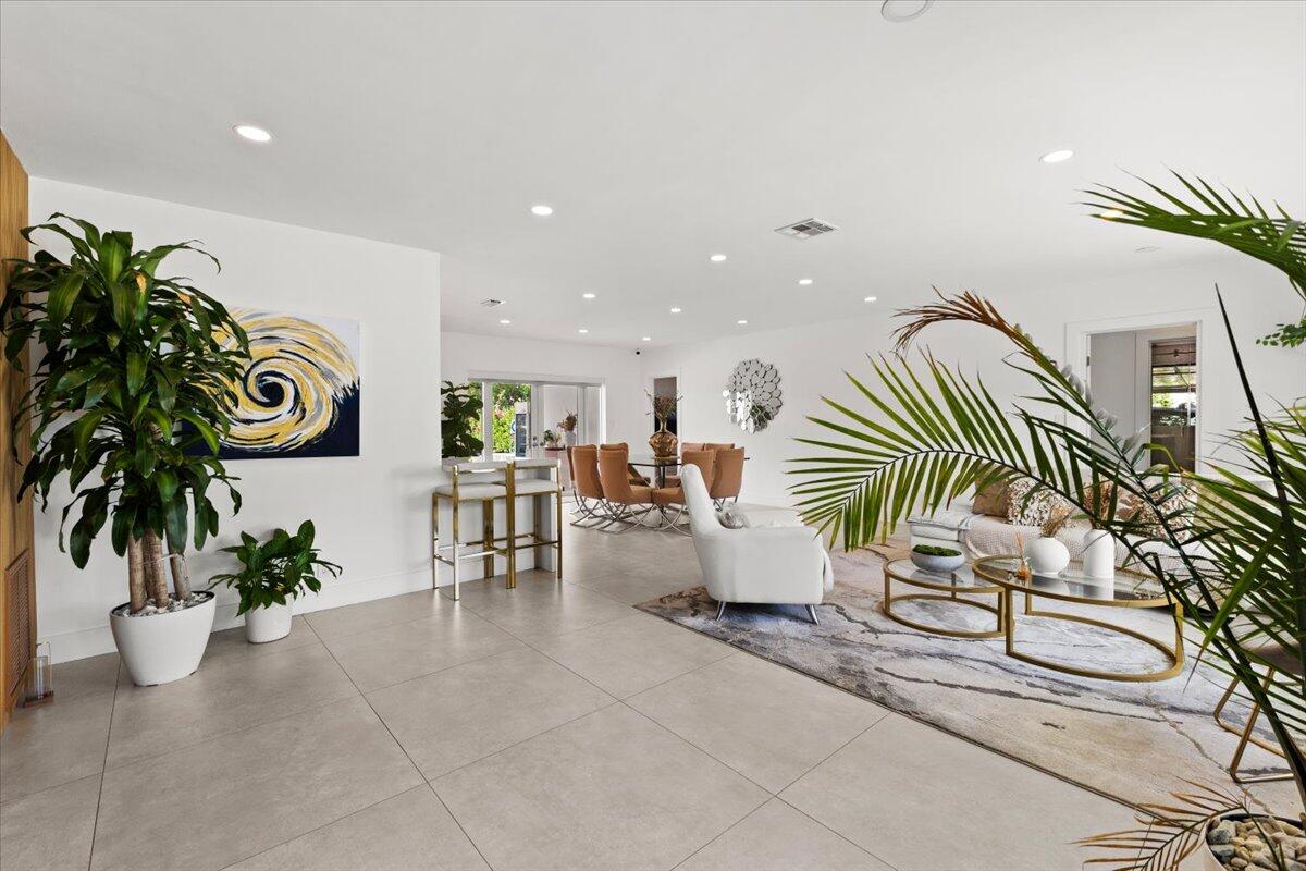 1049 West Palmetto Park Road Boca Raton, FL 33486 - Photo 5 of 40 a room with lots of white furniture and potted plants