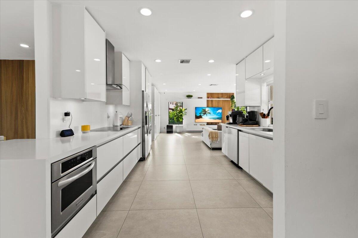 1049 West Palmetto Park Road Boca Raton, FL 33486 - Photo 10 of 40 a kitchen with stainless steel appliances a stove a sink and white cabinets