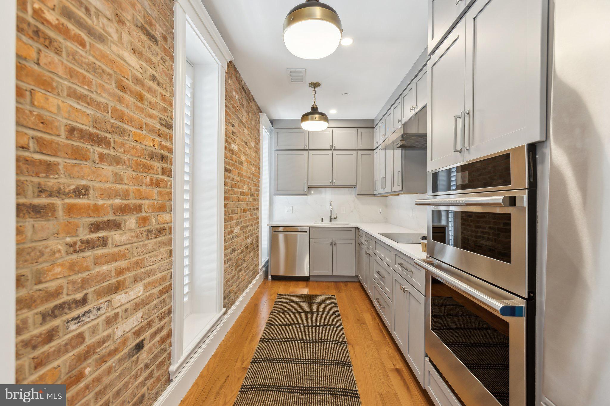 1641 R Street Northwest, Unit 201 Washington, DC 20009 - Photo 9 of 36 Chic kitchen with exposed brick charm.