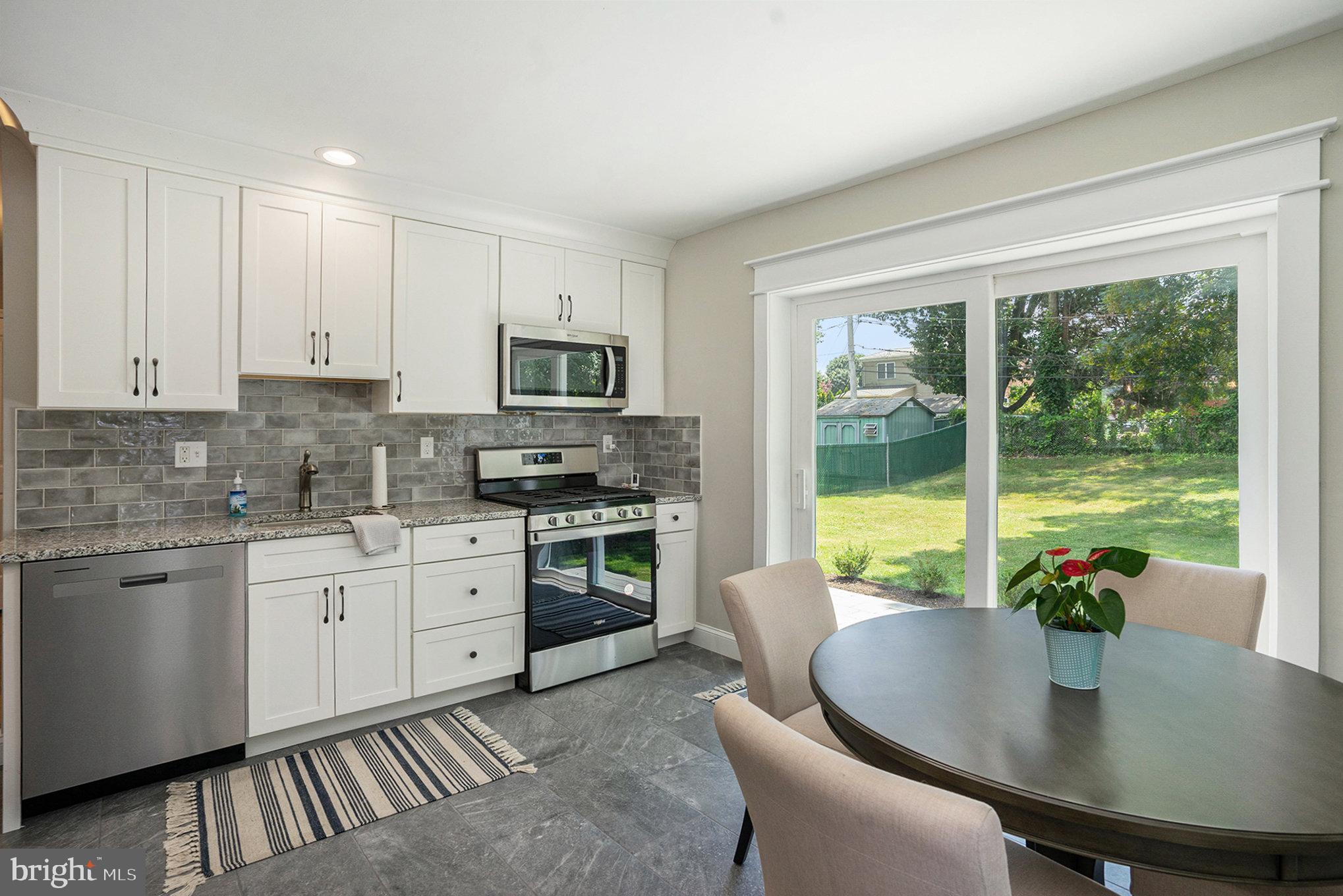 a kitchen with stainless steel appliances granite countertop a stove a kitchen island a table and chairs