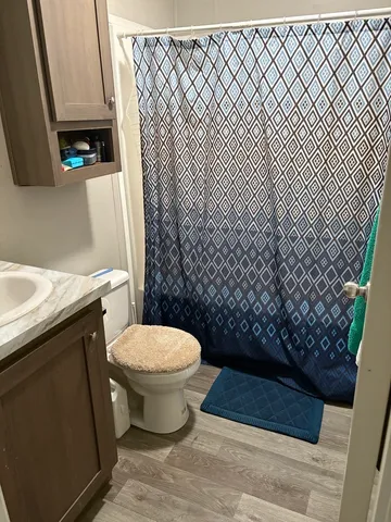 a bathroom with a granite countertop toilet and a sink