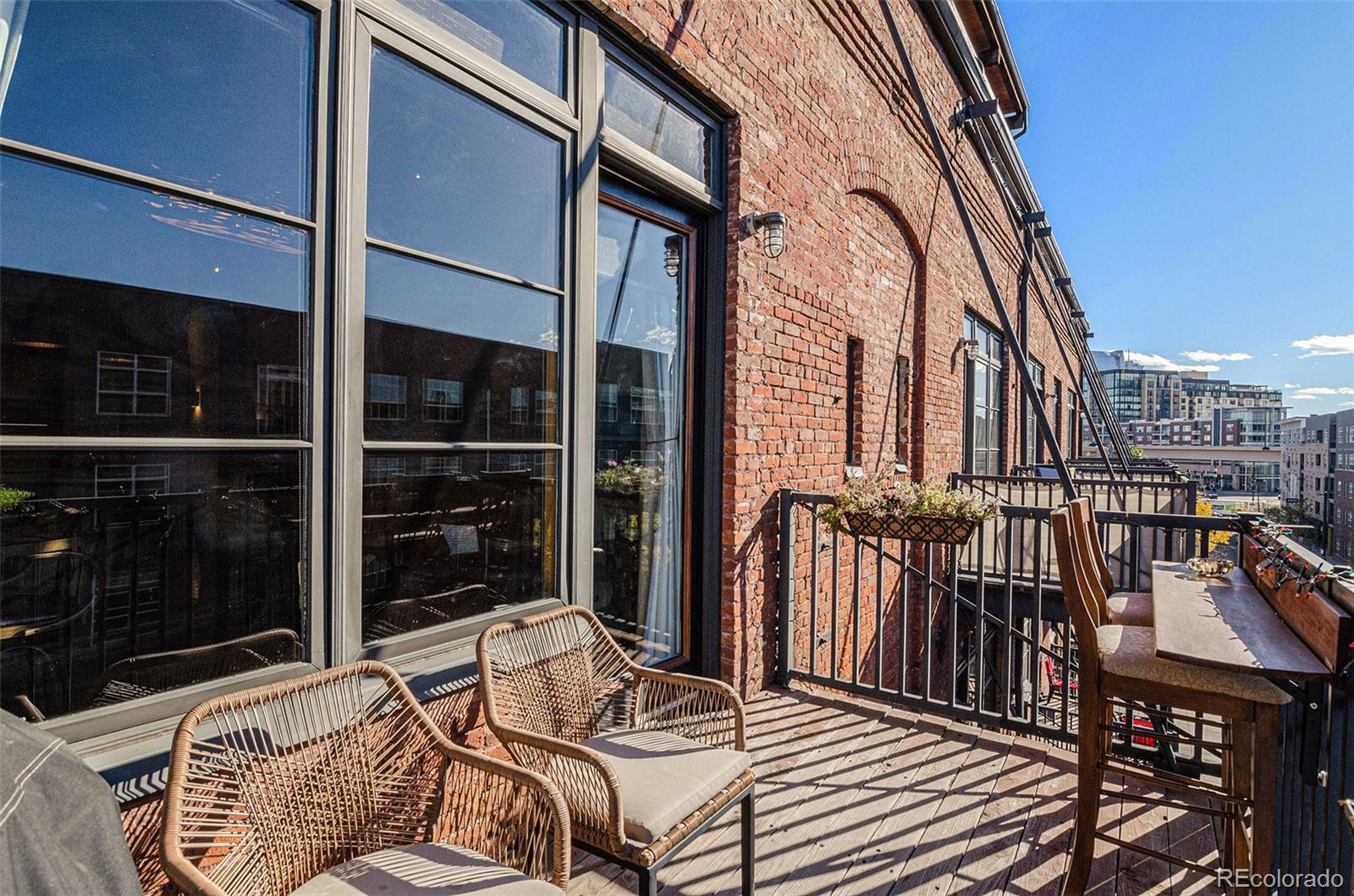 2960 Inca Street, Unit 417 Denver, CO 80202 - Photo 10 of 14 a view of a balcony with two chairs and a barbeque