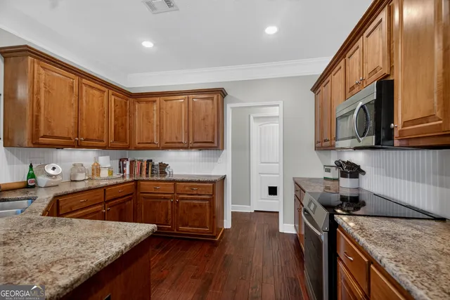 a kitchen with granite countertop a sink a stove and cabinets