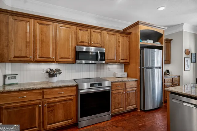 a kitchen with stainless steel appliances granite countertop a refrigerator stove and sink