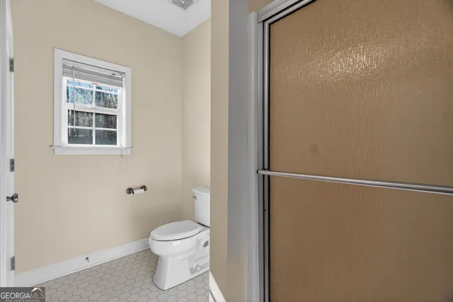 a bathroom with a toilet and a shower