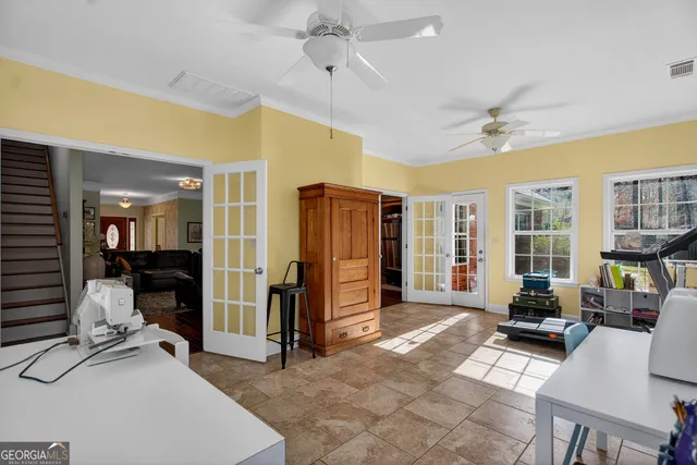 a living room with furniture a large window and gym equipment