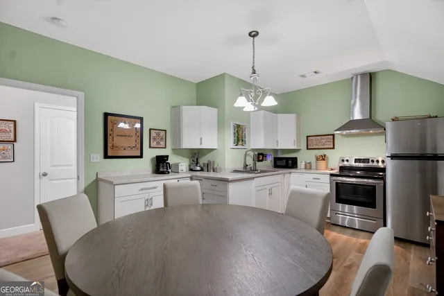 a large kitchen with kitchen island a stove a sink a dining table and chairs