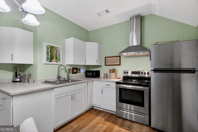 a kitchen with a stove a sink and a refrigerator