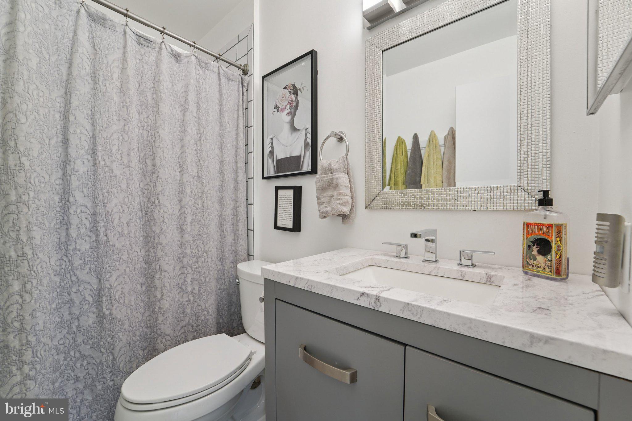 15108 Watergate Road Silver Spring, MD 20905 - Photo 21 of 33 a bathroom with a granite countertop sink vanity mirror and toilet