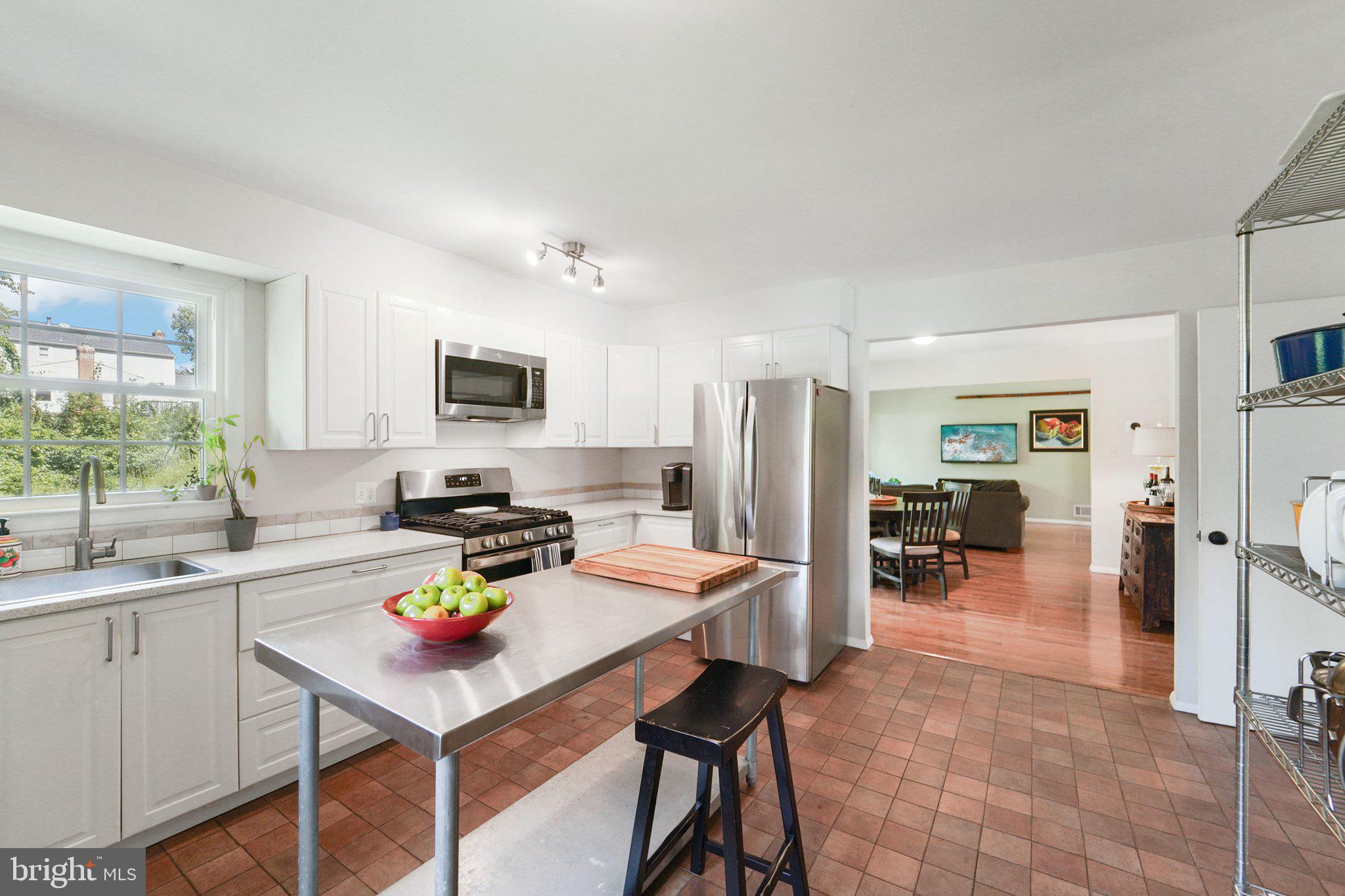 15108 Watergate Road Silver Spring, MD 20905 - Photo 10 of 33 a kitchen with a dining table chairs and refrigerator
