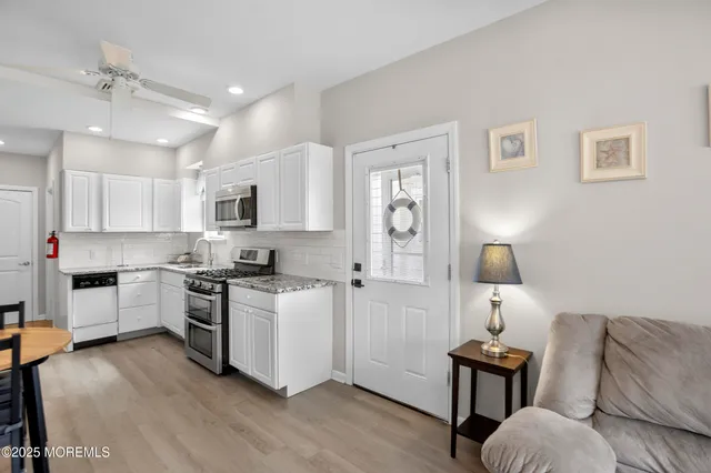 a kitchen with cabinets and wooden floor