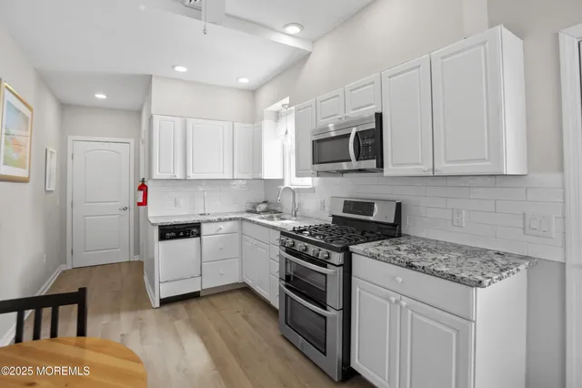 a kitchen with stainless steel appliances granite countertop a stove sink microwave and cabinets