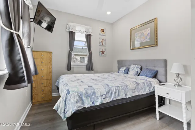 a bedroom with a bed a painting on the wall and a window