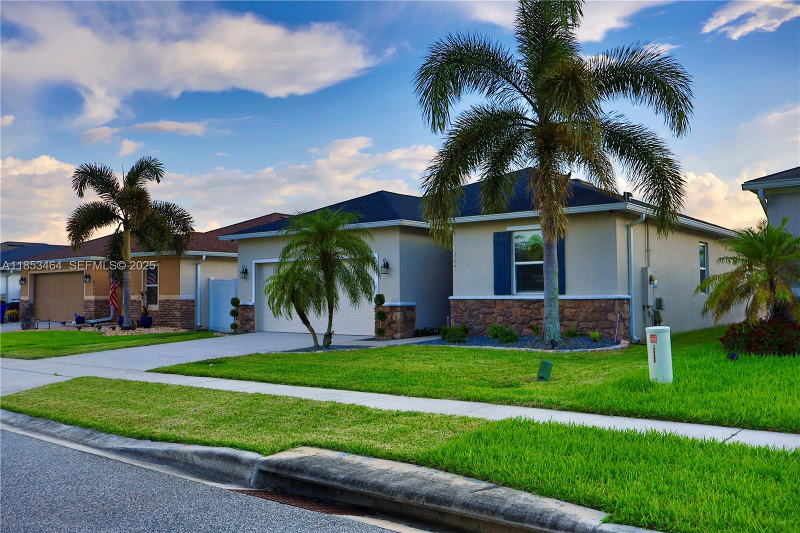 4582 Baler Trails Drive St. Cloud, FL 34772 - Photo 1 of 27 front view of a house with a yard and palm trees