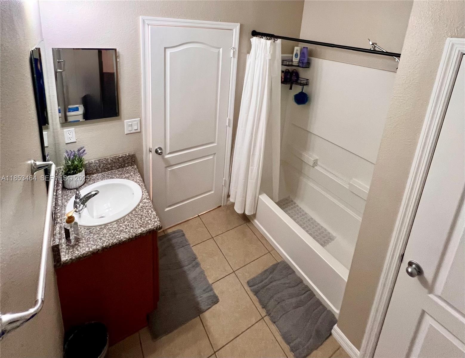 4582 Baler Trails Drive St. Cloud, FL 34772 - Photo 18 of 27 a bathroom with a granite countertop sink and a mirror