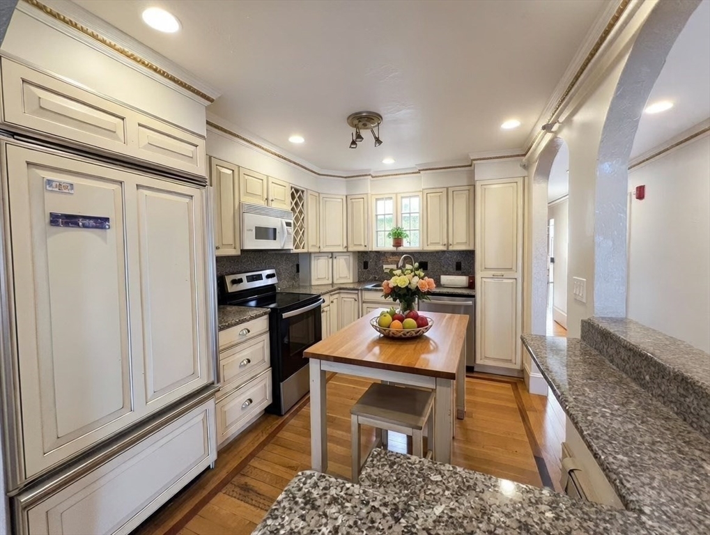 1002 Beacon Street Brookline, MA 02446 - Photo 10 of 17 a kitchen with stainless steel appliances kitchen island granite countertop a refrigerator and a stove top oven