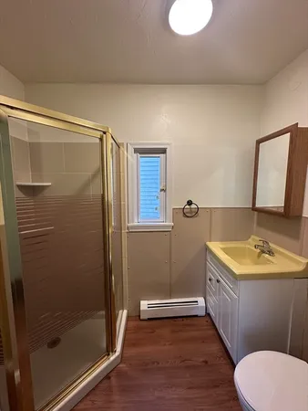 a bathroom with a granite countertop sink toilet and shower