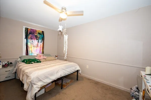 a bedroom with a bed wall painting and a window