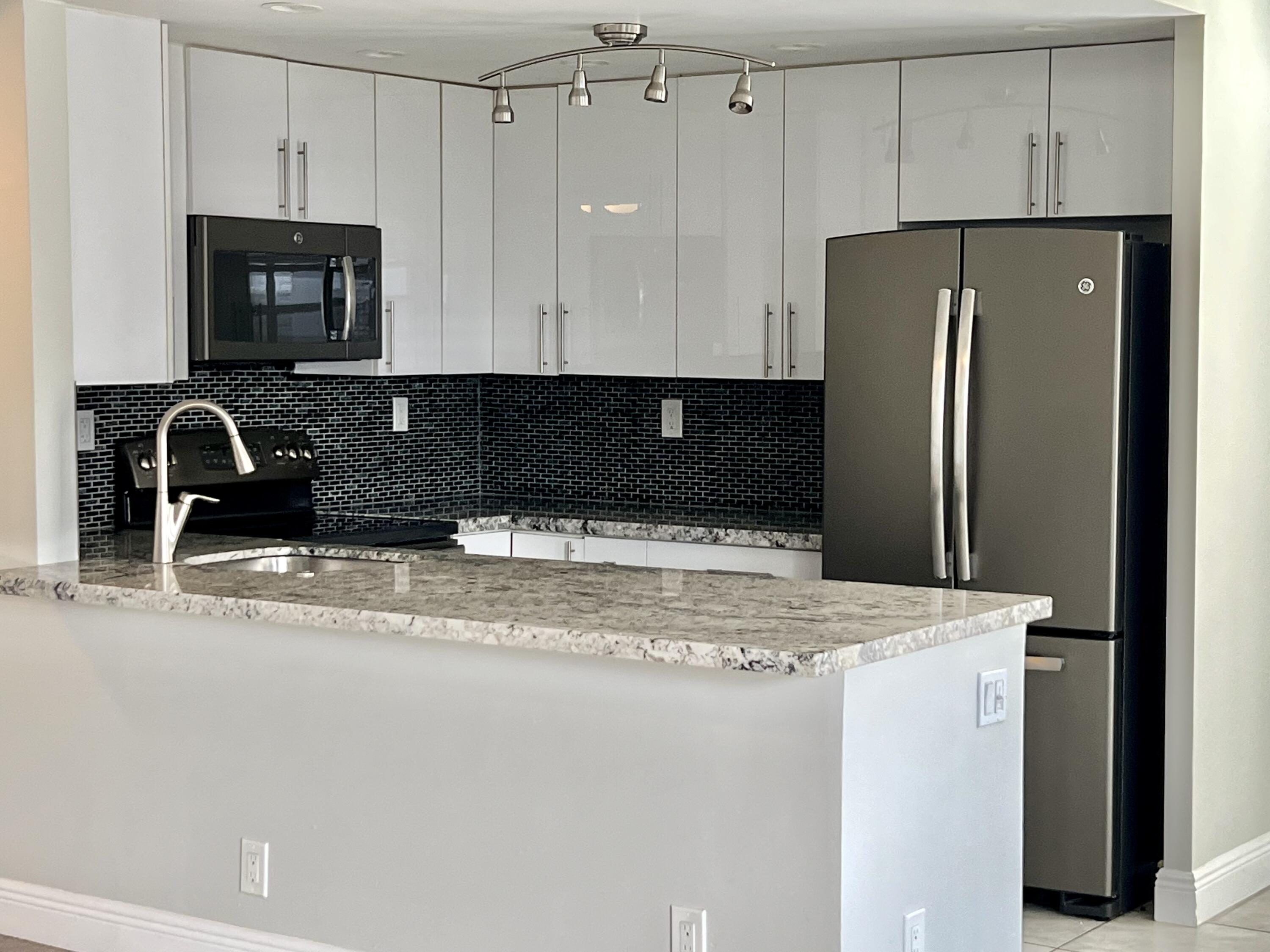 150 Burgandy Way, Unit D Delray Beach, FL 33484 - Photo 1 of 33 a kitchen with granite countertop a refrigerator and a sink