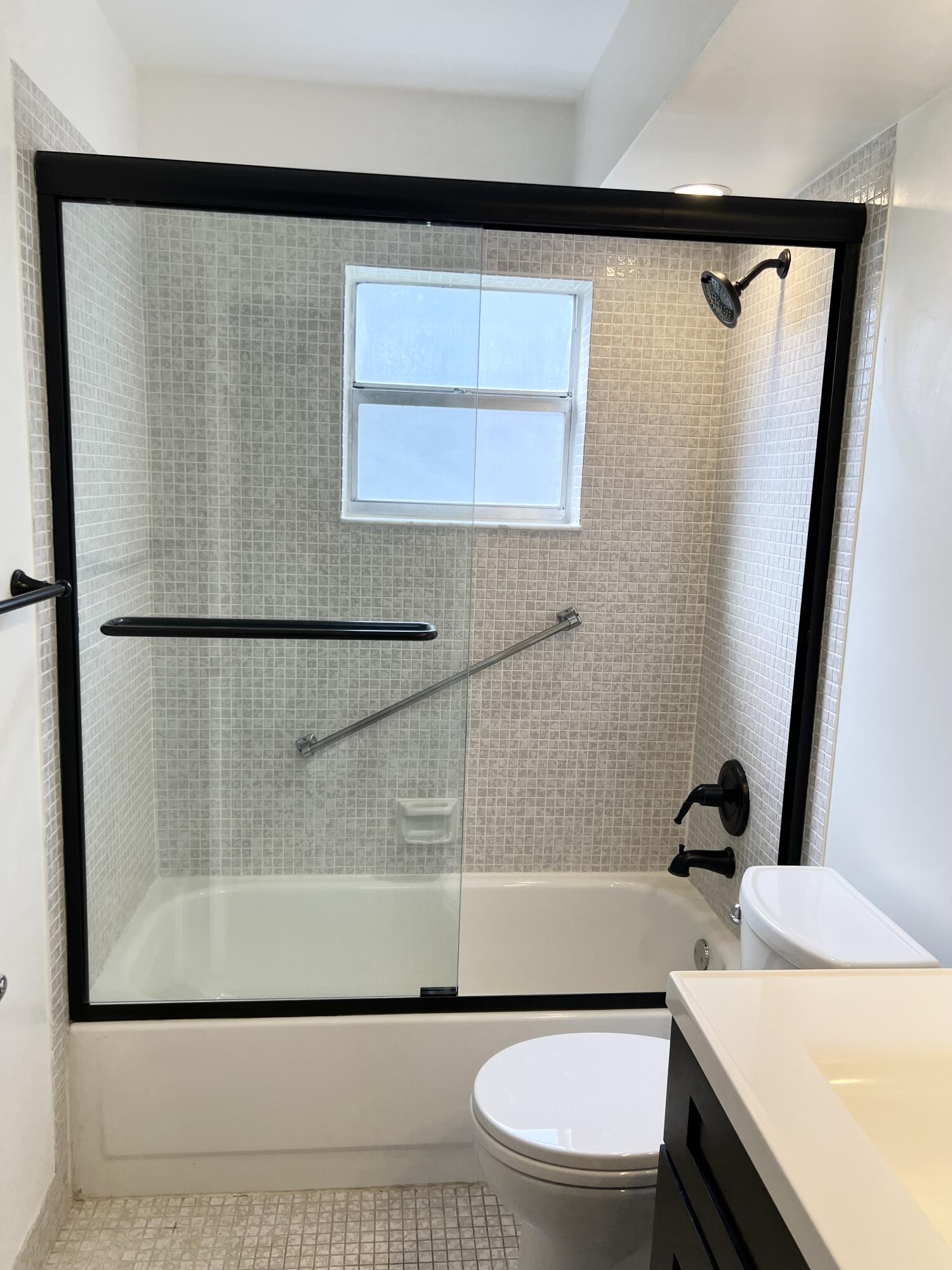 150 Burgandy Way, Unit D Delray Beach, FL 33484 - Photo 12 of 33 a bathroom with a sink a toilet and shower