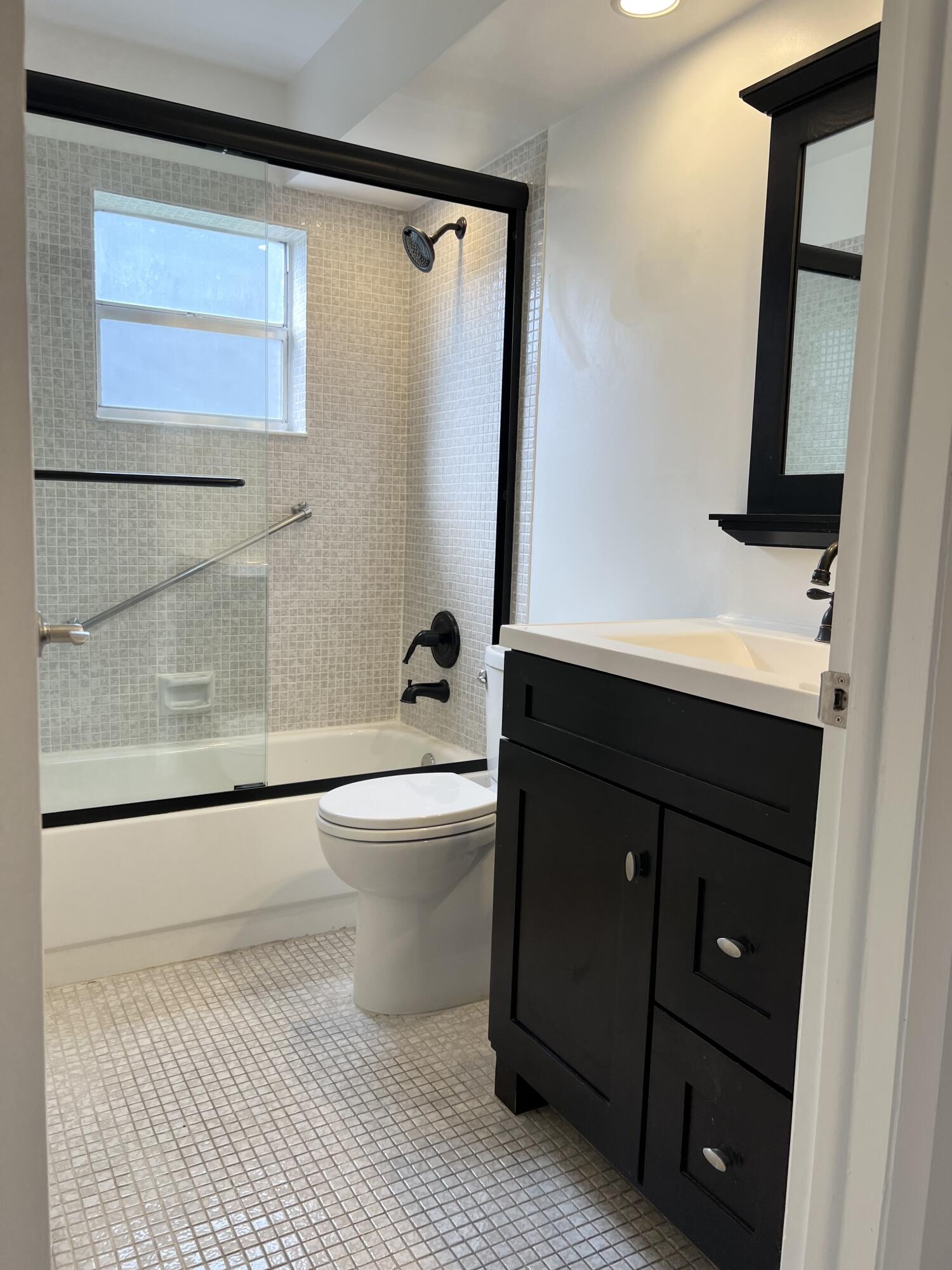 150 Burgandy Way, Unit D Delray Beach, FL 33484 - Photo 13 of 33 a bathroom with a sink a toilet and shower