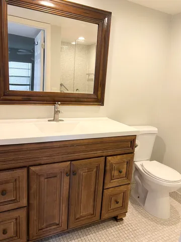 a bathroom with a toilet a sink and mirror