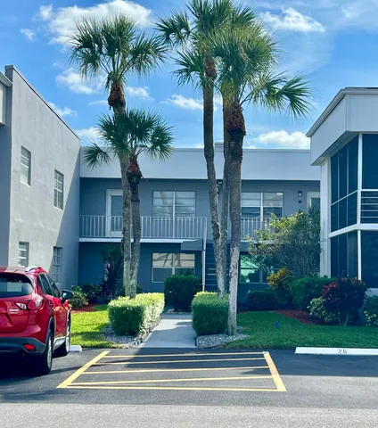 a front view of a house with garden and parking
