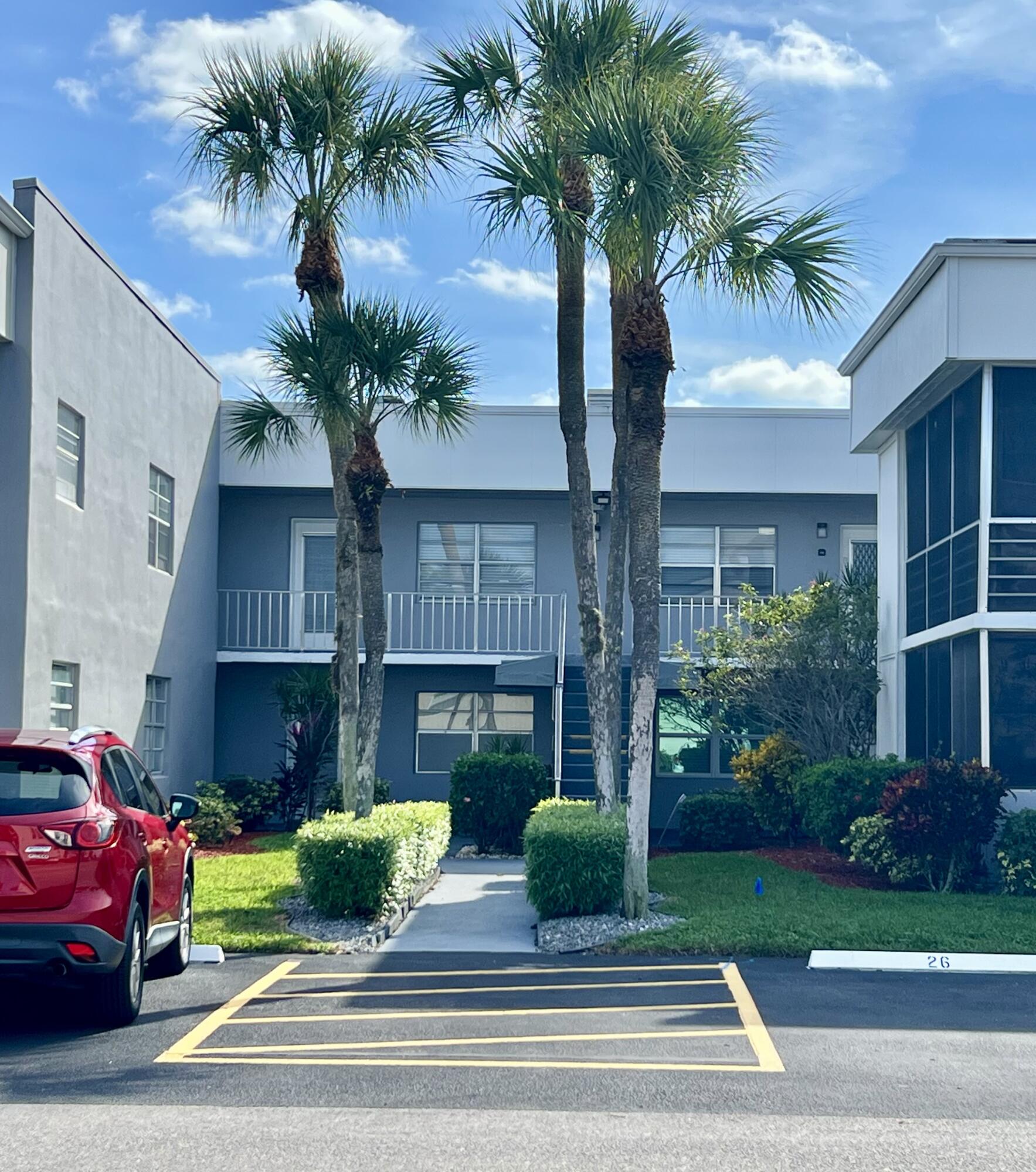 150 Burgandy Way, Unit D Delray Beach, FL 33484 - Photo 2 of 33 a front view of a house with garden and parking