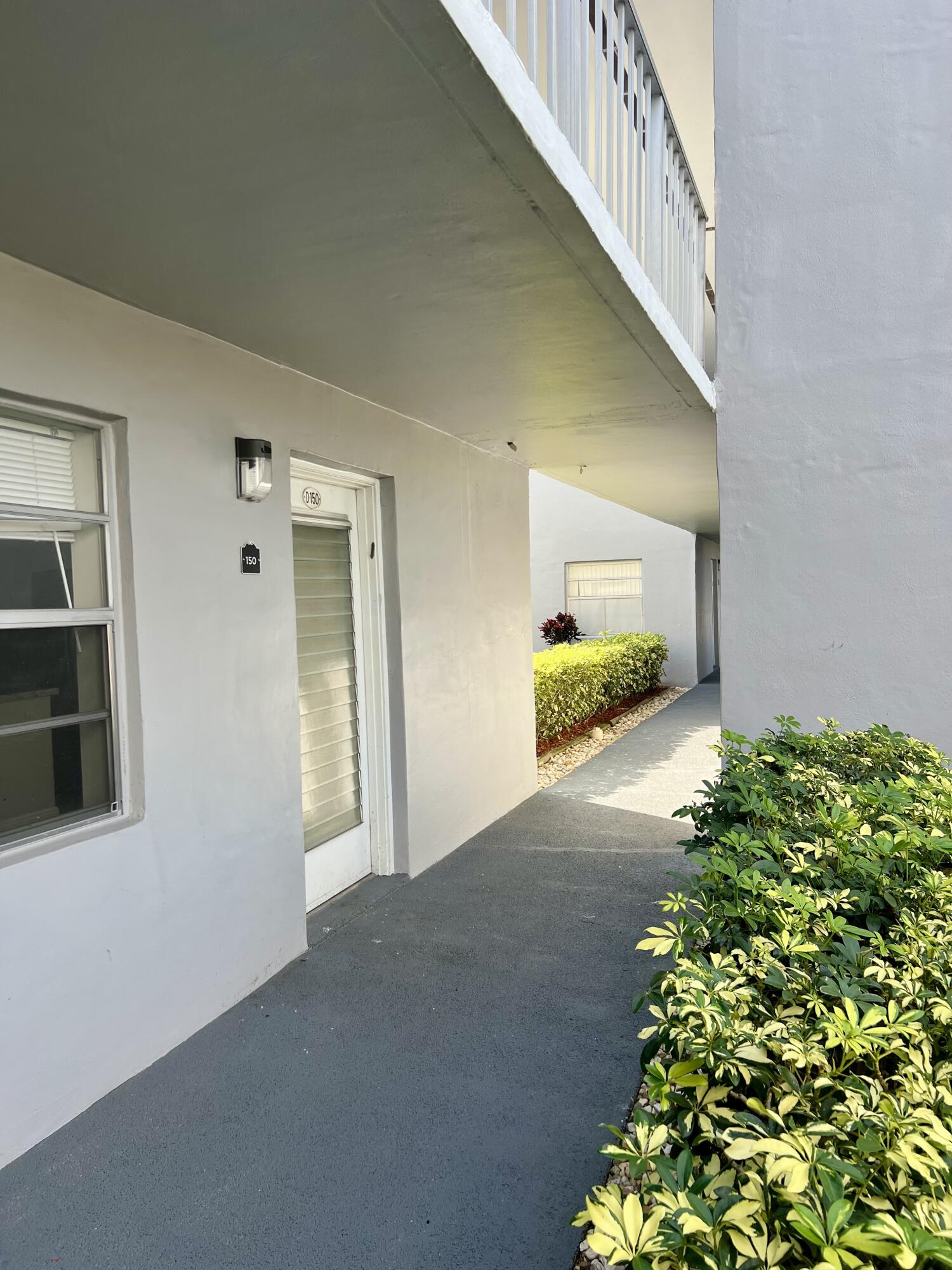 150 Burgandy Way, Unit D Delray Beach, FL 33484 - Photo 21 of 33 a view of a hallway with wooden floor and plants