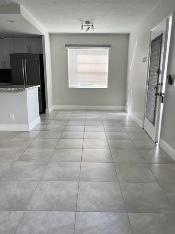 a view of an empty room with a kitchen