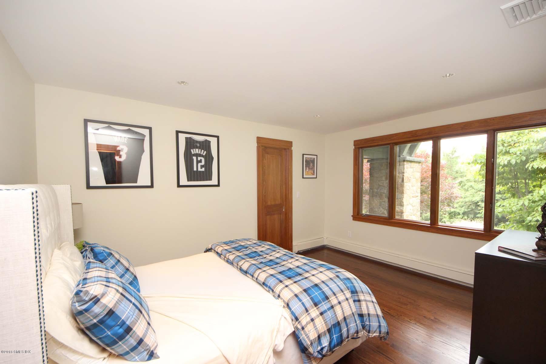 55 Cutler Road, Unit MAIN HOUSE Greenwich, CT 06831 - Photo 12 of 18 a bedroom with a bed and a large window