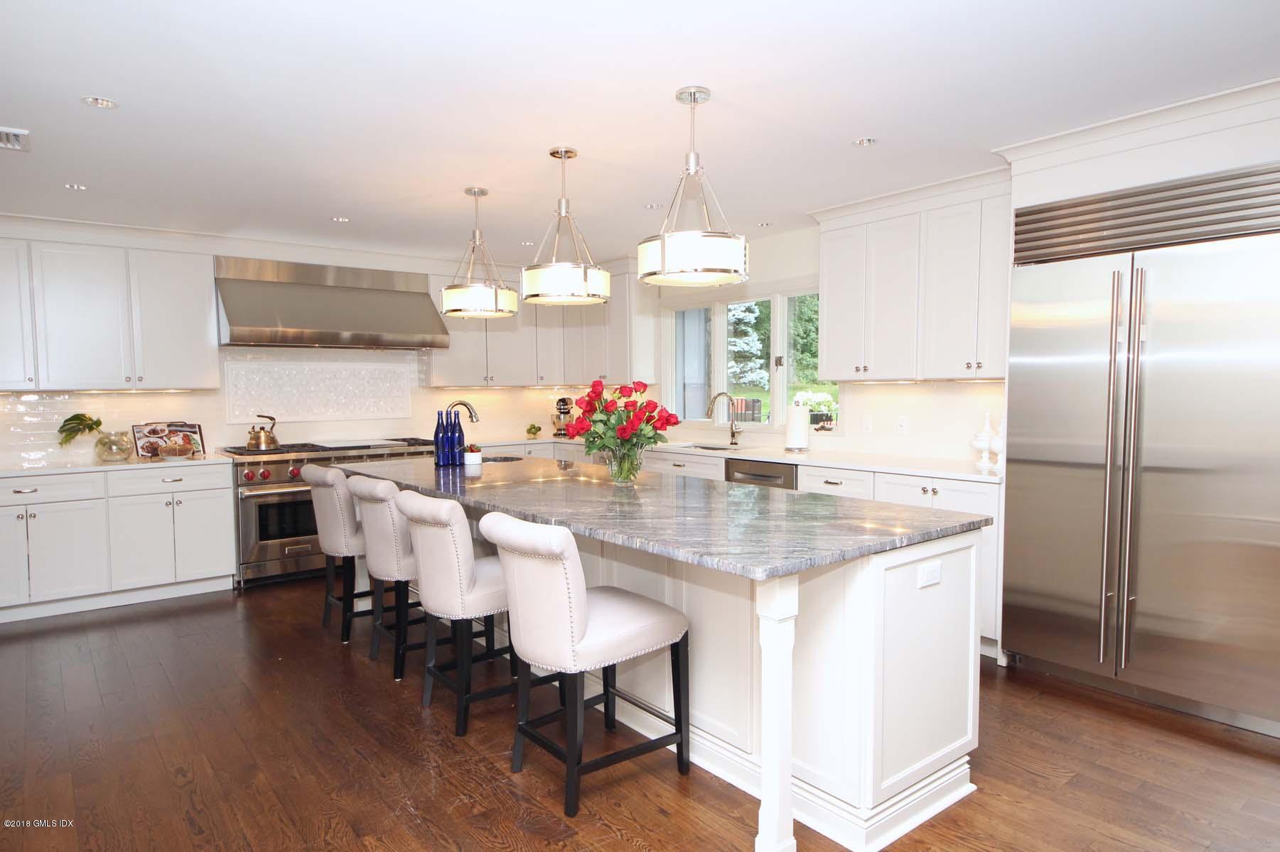 55 Cutler Road, Unit MAIN HOUSE Greenwich, CT 06831 - Photo 3 of 18 a kitchen with kitchen island granite countertop a table and chairs in it