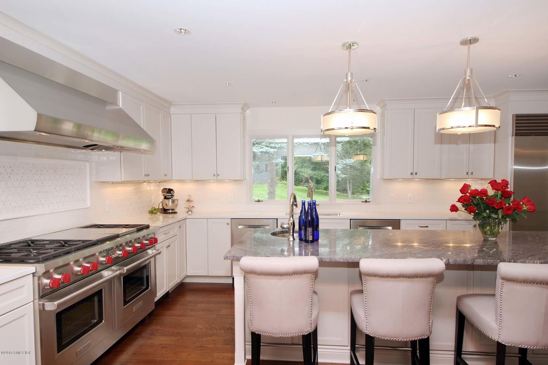 55 Cutler Road, Unit MAIN HOUSE Greenwich, CT 06831 - Photo 4 of 18 a kitchen with a stove a sink and a dining table