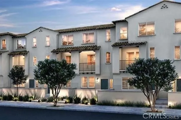 a front view of a house with plants and parking