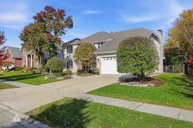 a front view of a house with a yard and a garage