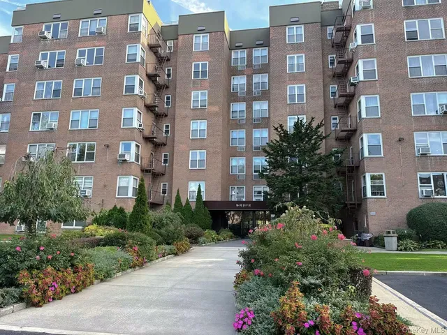 a front view of a multi story building with a yard