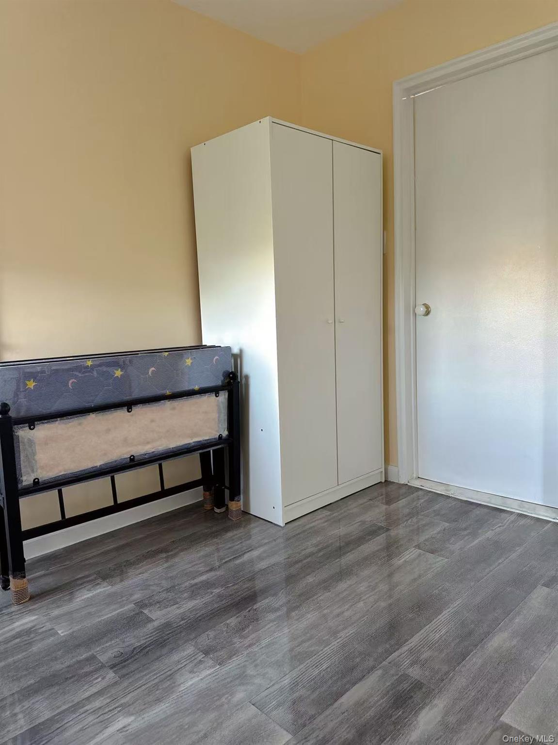 18-40 211th Street, Unit 5A Queens, NY 11360 - Photo 7 of 21 a view of a room with wooden floor and a window