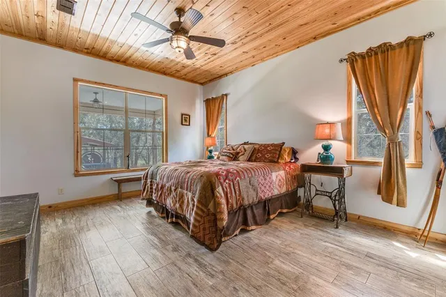 a spacious bedroom with a bed and wooden floor