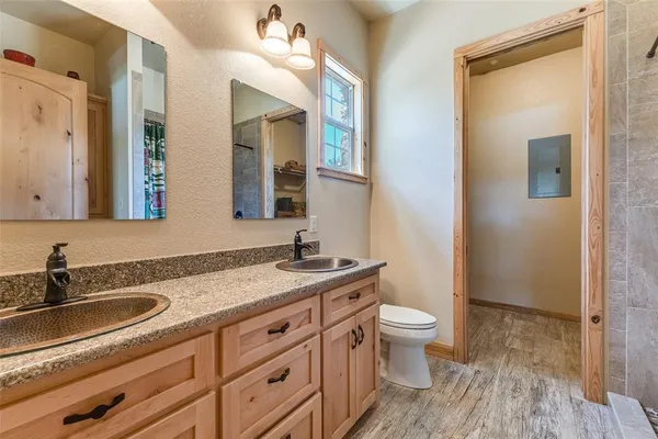 a bathroom with a granite countertop sink a toilet and a mirror