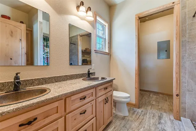 a bathroom with a granite countertop sink a toilet and a mirror